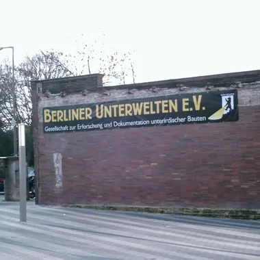 Berliner Unterwelten e.V. - U-Bahnhof Gesundbrunnen - Eingang mit Schriftzug und Logo 'Berliner Unterwelten e.V.'