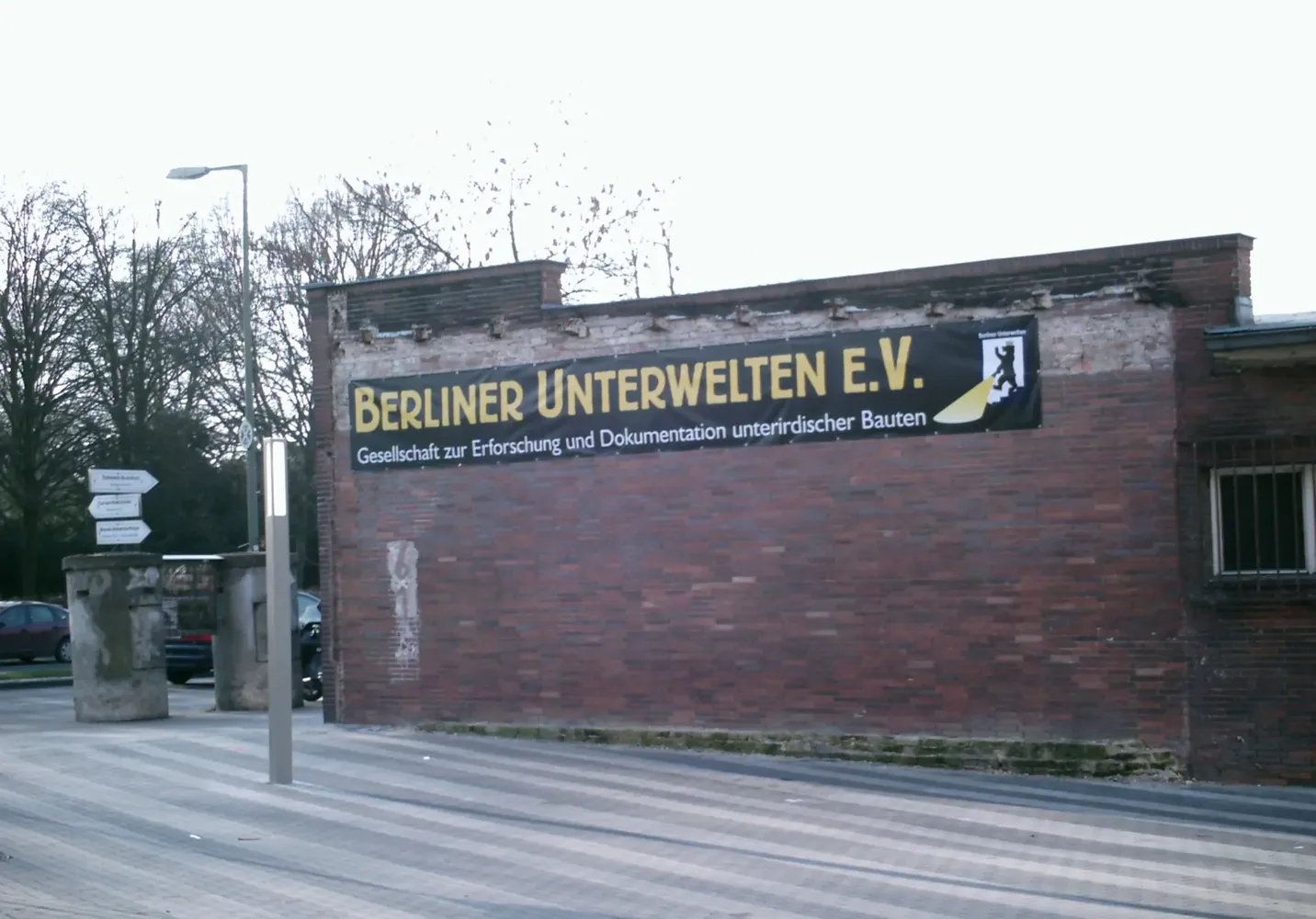 Berliner Unterwelten e.V. - U-Bahnhof Gesundbrunnen - Eingang mit Schriftzug und Logo 'Berliner Unterwelten e.V.'