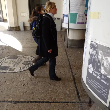 DenkStätte Weiße Rose - Visitors Walk Past White Rose Poster at Entrance to Main Building of Ludwig-Maximilians-Universitat - Munich - Germany