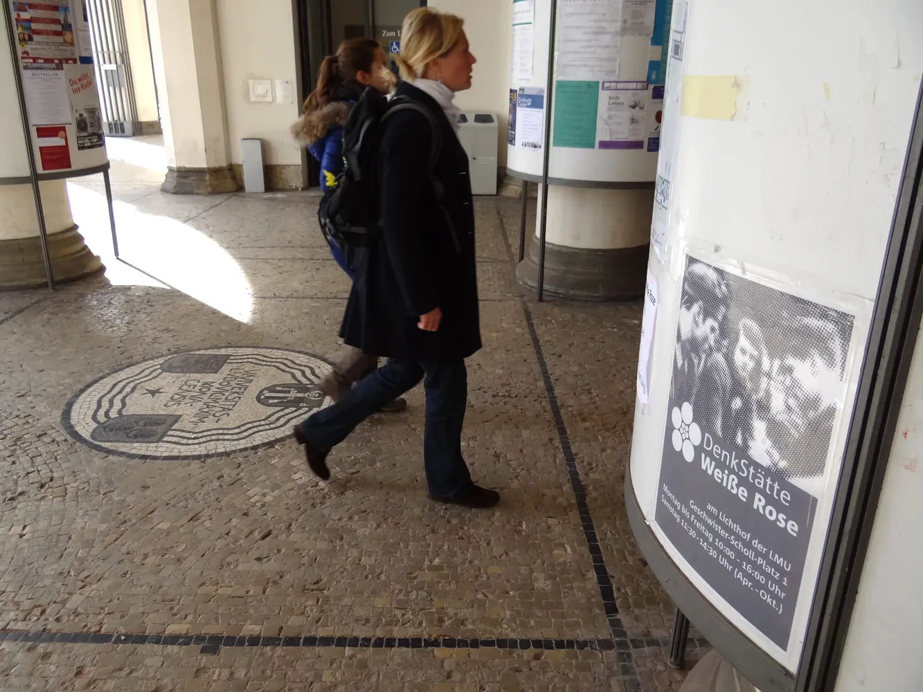DenkStätte Weiße Rose - Visitors Walk Past White Rose Poster at Entrance to Main Building of Ludwig-Maximilians-Universitat - Munich - Germany